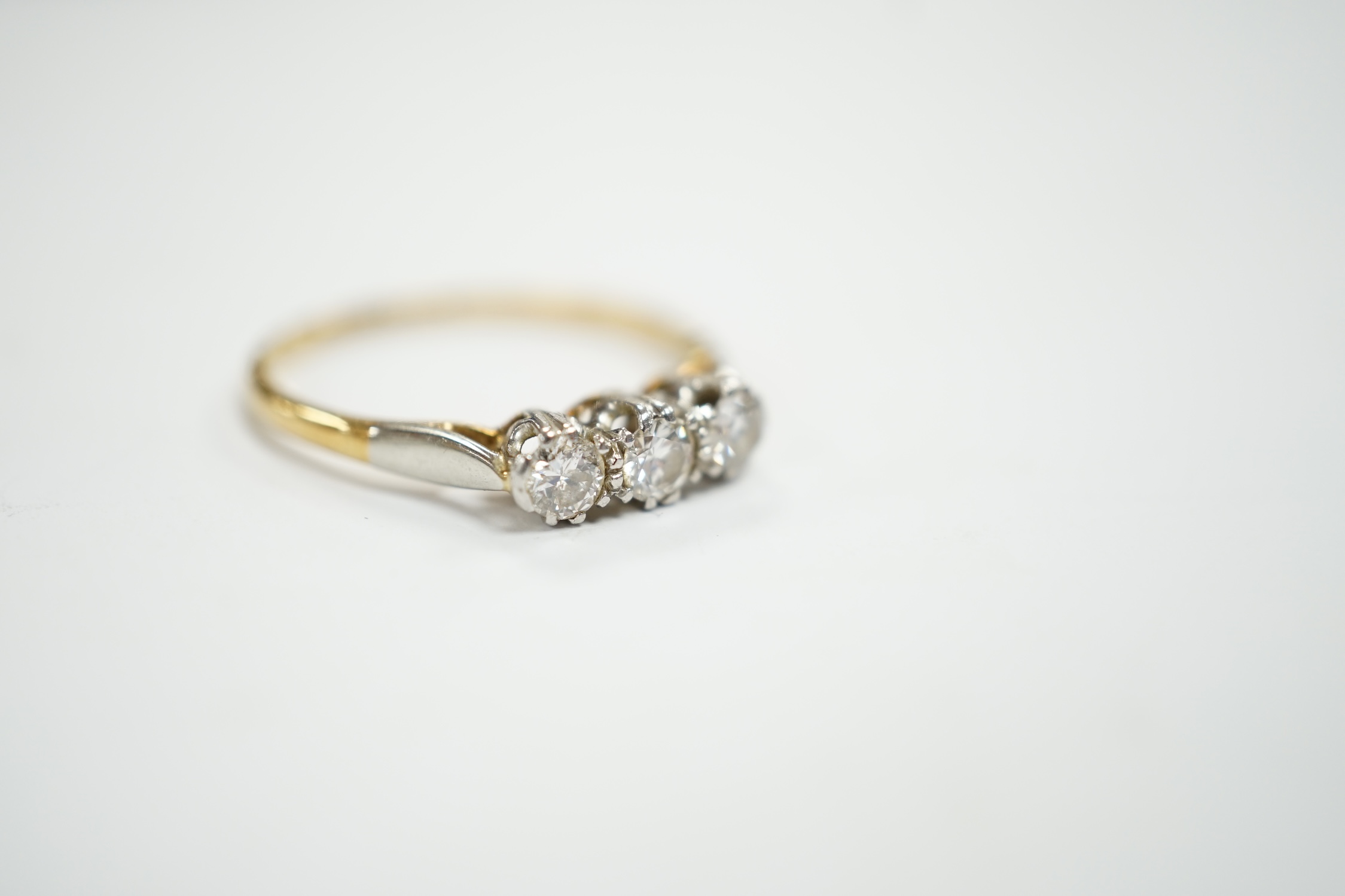 An 18ct, plat and three stone diamond set ring, size P/Q, size 2.6 grams.